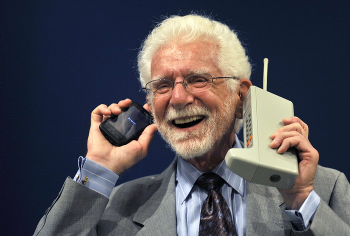 U.S. engineer Martin Cooper holds the Motorola DynaTAC phone, the world's first commercial handheld cellular phone, and his current mobile phone during a news conference in Oviedo